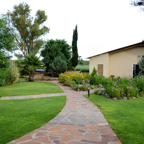 Gepflegte Gartenanlage und Gästeunterkunft der Ombakata Lodge in Namibia